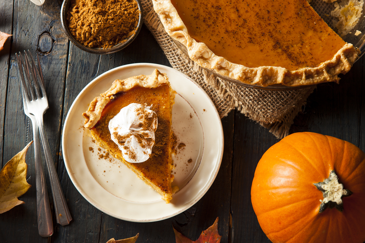 Photo of a slice of pumpkin pie with a dollop of cream on the top