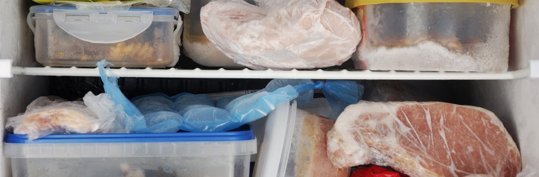 Frozen food in labelled tubs and bags on freezer shelves